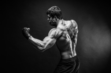 Wall Mural - Studio portrait of fighting muscular man in smoke.