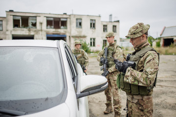 soldiers at the checkpoint stopped a car.