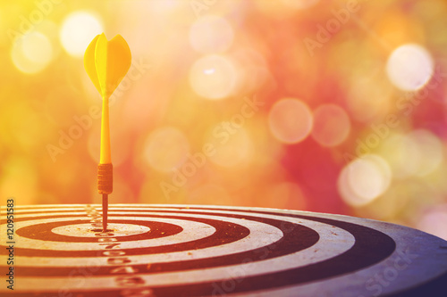 Fotografía target dart with arrow over blurred bokeh background ,metaphor to target marketing or target arrow concept