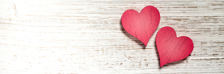 Wall Mural - two red hearts on wooden background