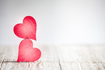 Wall Mural - two red hearts on wooden background