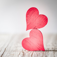 Wall Mural - two red hearts on wooden background