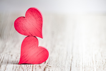 Wall Mural - two red hearts on wooden background