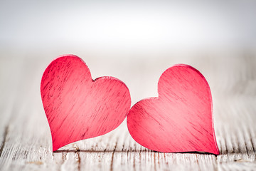 Wall Mural - two red hearts on wooden background
