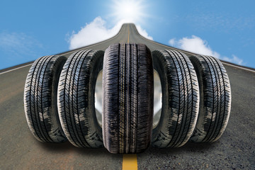 Car tires in row on the street with blue sky background.