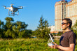 © scaliger - Man operating drone quad copter in city park