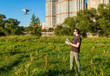 © scaliger - Man operating a drone quad copter in city park