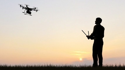 Man operating a drone at sunset using a controller