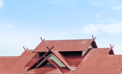 red Roof house with tiled roof on blue sky