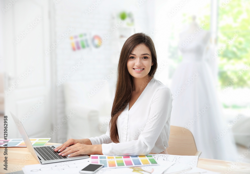 Pretty young dress designer at workplace