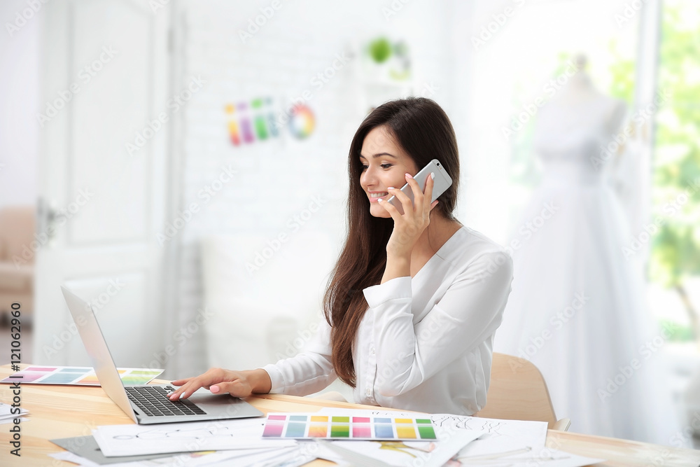 Pretty young dress designer at workplace