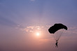 Silhouette of parachute on sunset background