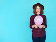 © kegfire - Young redhead woman holding pink balloon