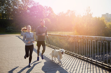 Canvas Print - happy couple with dog running outdoors