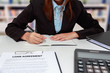 Hands of business woman writing on notebook with calculator