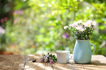 Wall Mural - Flowers with vintage pot and heart shaped cup on wooden table