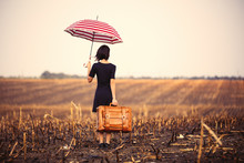 Young Woman With Suitcase And Umbrella