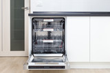 Fototapeta Tulipany - Build-in dishwasher with opened door in a white kitchen 
