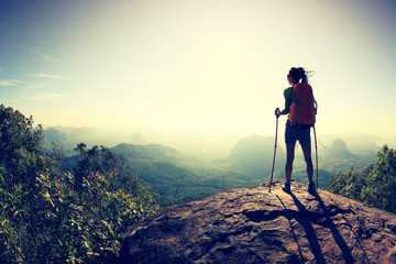 successful woman hiker at sunrise mountain peak