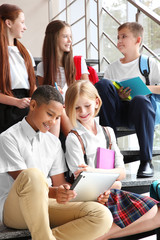 Sticker - Schoolchildren sitting on stair-steps near window at school