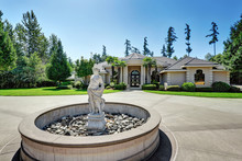 Suburban Luxury House With Fountain Statue In The Front Yard