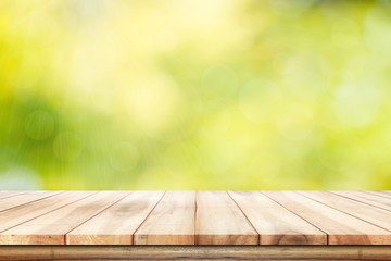 Wall Mural - Empty wooden  table with foliage bokeh background. Ready for product display montage.