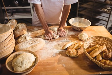 Mid-section of baker kneading a dough