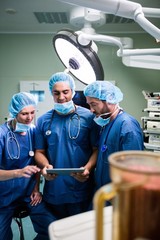 Poster - Surgeons discussing over digital tablet in operation room