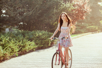 Wall Mural - The young girl with bicycle in park