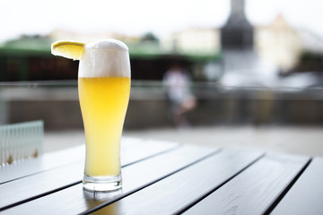 Wheat beer with slice of lemon on table