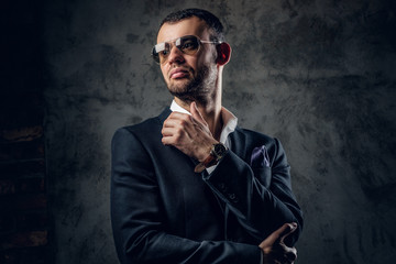 Portrait of male in sunglasses and grey business jacket.