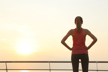 Poster - Young woman doing exercises on pier