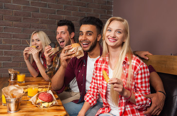 Wall Mural - People Group Eating Fast Food Burgers Sitting At Wooden Table In Cafe