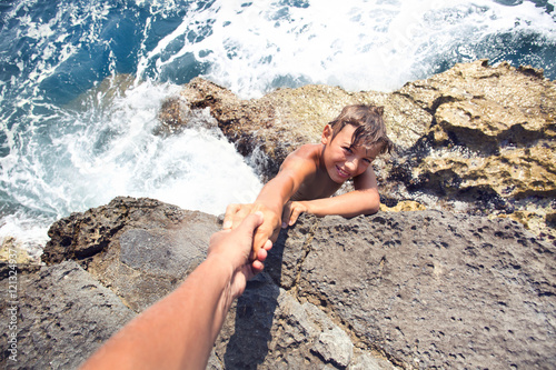Fotografie, Obraz guy in danger asking for help to someone to climb an inaccessibl