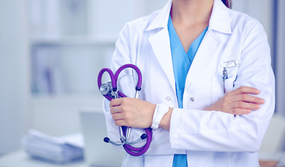 Wall Mural - Portrait of happy successful young female doctor holding a stethoscope