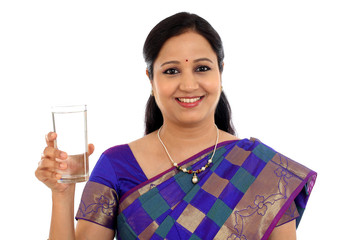 Happ young traditional woman drinking glass of water