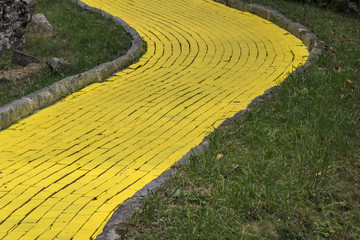 Winding yellow brick road with stone edges and a shallow depth of field