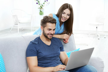 Sticker - Beautiful young couple using laptop at home