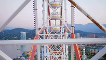The Design Of The Ferris Wheel With The Height Of Raised Booths. The Wheel Moves And Picks Up People On It.