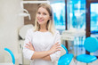 © mintybear - people, medicine, stomatology and healthcare concept - happy young female dentist with tools over medical office background