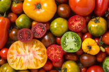 Close Up Of Colorful Tomatoes, Some Sliced, Shot From Above