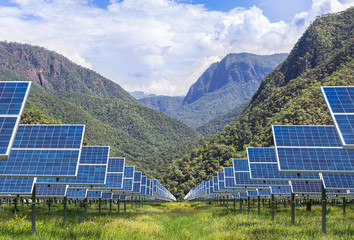 Wall Mural - solar photovoltaics panels in solar power station with mountains background