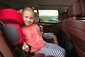 Wall Mural - Portrait of happy little child girl sitting comfortable in car s