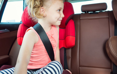 Wall Mural - Portrait of happy little child girl sitting comfortable in car s