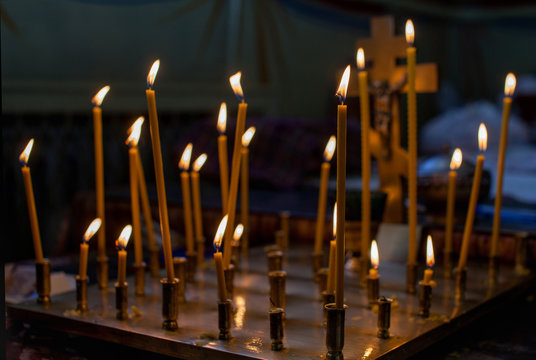Church candles standing in the temple on the stand during the service. Religious Orthodoxy and Catholicism symbol.