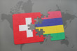 puzzle with the national flag of switzerland and mauritius on a world map background.