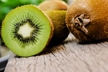 Some fresh Kiwi Fruits (selective focus) on an old wooden table, half of kiwi