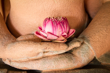 Wall Mural - Lotus in the hands of sandstone Buddha.