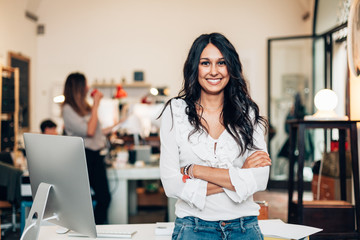 portrait of smiling woman standing in modern office