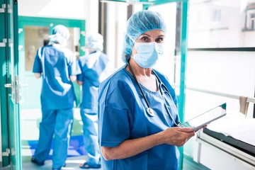 Poster - Surgeon using digital tablet in corridor